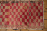 Distressed Oushak rug with cherry red, beige checkered pattern and short pile.