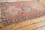 Distressed vintage Oushak rug side border in navy, beige, and madder red geometric motifs.