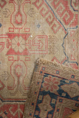 Distressed Oushak rug pile in red, beige, and navy, with visible hand-knotted reverse.