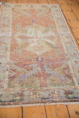 Distressed Oushak rug section showing wear across knot heads, copper and pale blue.