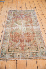 Distressed Oushak runner's geometric border and fringe, in copper and dusty blue.