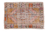 Distressed vintage Oushak rug featuring elongated medallion, seed motifs, and tangerine accents.