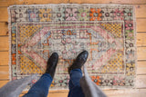 Softened palette and distressed texture of a vintage Oushak rug with plum and saffron.