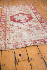Distressed Oushak runner edge with cherry red and ivory geometric florals, revealing textured wear.
