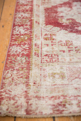Distressed Oushak runner border showcasing cherry red and ivory geometric floral patterns with even wear.
