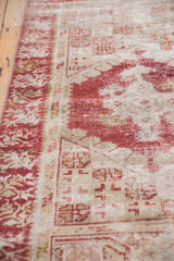 Distressed vintage Oushak runner with faded cherry red and ivory geometric motifs.