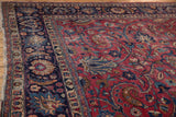 Cochineal red field of the vintage Meshed carpet with sprawling floral motifs and knot heads.