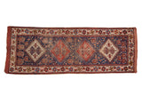 Antique Afshar runner featuring diamond medallions, people motifs, indigo blue, brick red, and ivory.