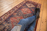 Ornate boteh and medallion patterns on an antique Afshar runner, brick red and indigo.