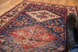 Antique Afshar runner's ivory geometric medallion, indigo and brick red field, with even wear.