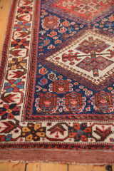 Afshar rug's hand-knotted texture showing detailed ivory border with madder red patterns.