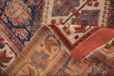 Folded antique Afshar rug edge reveals madder root red backing and even pile wear.
