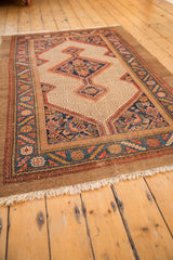 Secured fringe end of a vintage Camel Hair Serab rug with light wear.