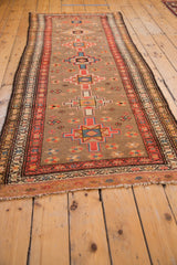Fringe and geometric border in faded tangerine orange and pale grapefruit red tones.