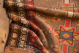 Close-up of Serab runner's geometric medallion, vine border, and earthy brown field.