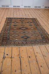 Geometric diamond motifs on a natural camel hair field with an aubergine Persian border.