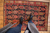 Vintage Caucasian rug's left border and geometric field motifs in madder root red, indigo, ivory.