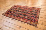 Hand-knotted Vintage Caucasian rug's geometric pattern, abrashed indigo ground, madder red, and beige.