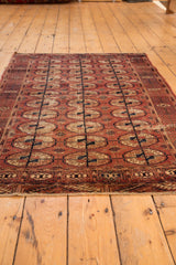 Visible texture of repeating gul medallions and unique germinating plant border on the antique Tekke rug.