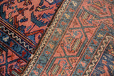 Tattered side and worn pile of a Vintage Malayer rug, featuring raspberry red and navy blue.