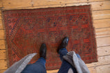 Antique Beshir rug showing repeating geometric gul medallions with pile wear and foundation visible.