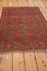 Antique Beshir rug corner showing madder red spandrel overlays with navy starburst motifs.