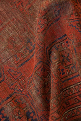 Antique Beshir rug: worn madder root red and chocolate brown pile, with geometric gul medallions.