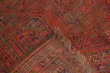 Antique Turkmen Beshir rug corner detail with foundation wear, madder red pattern, and fringe.