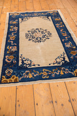 Antique Chinese Peking rug, ivory field, curvilinear floral motif, cobalt blue border.