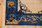 Antique Peking rug corner: cobalt blue border, gold vinery, tree motif, worn pile, tattered edge.