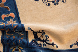 Close detail of antique Peking rug's cobalt blue border with scrolling trees and vinery.