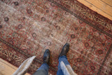 Antique Malayer rug with wear across knot heads, madder red, ivory, and blue Herati pattern.
