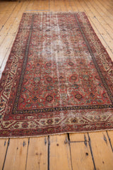 Antique Malayer runner: madder red and blue Herati motif field, floral pomegranates, and wear.