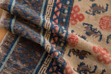 Textured pile of antique Ningxia runner, highlighting blue endless knot and brown bat motifs.