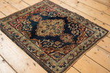 Corner detail of antique Kermanshah rug, featuring scrolling vinery and pawn design border.