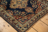Antique Persian Kermanshah rug corner: navy field, reciprocating pawn border, scrolling vinery.