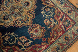 Kermanshah rug's pawn border, scrolling vinery, navy, wine, dusty gold, showing knot heads.