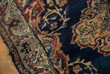 Antique Kermanshah rug: navy blue field with dusty gold tendrils and dusty blue border.