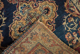Antique Kermanshah rug's navy pile and intricate hand-knotted foundation with scrolling vinery.