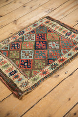 Antique Jaff Kurd bagface corner, showing finned floral border, geometric panels, and knot heads.