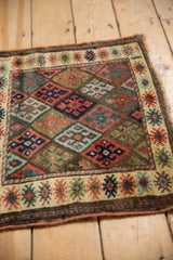 Close-up of the antique Jaff Kurd rug's border with finned floral motifs on ivory.