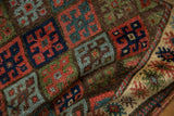 Antique Jaff Kurd rug close-up: brick red, blue, green diamond panels and finned border texture.