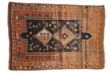 Vintage Caucasian rug, double medallion, tribal motifs, terra cotta, navy, orange, showing wear.