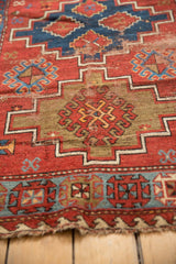 Geometric guls and stepped contours of a vintage Caucasian rug, showing wear.