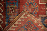 Hand-knotted Caucasian rug detail, showing geometric red, blue pile and reverse woven foundation.