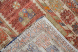 Folded vintage distressed Oushak rug, showing hand-knotted foundation and worn pile detail.
