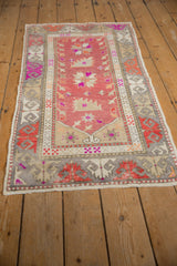 Vintage distressed Oushak rug's secured end, showing raspberry red and beige textile texture.
