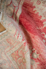 Distressed vintage Oushak rug pile with cherry red, blush, and ivory color variation.