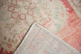 Distressed Oushak rug pile with blush-red patterns, even wear, and woven backing.