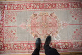 Distressed vintage Turkish Oushak rug, faded slate and blush roundel floral medallion.